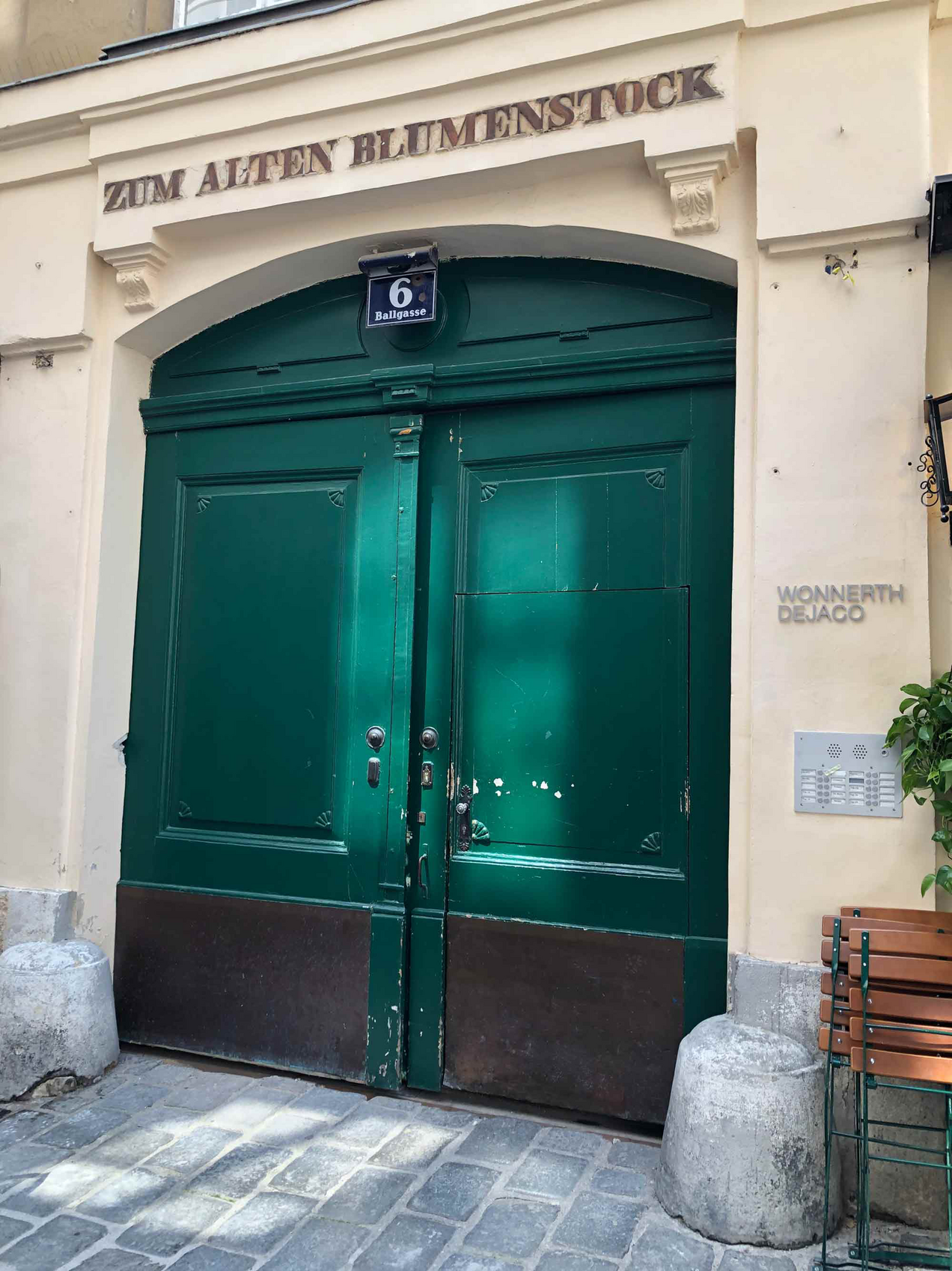 Fassade der Galerie Wonnert Dejaco in Wien, über dem grünen Tür steht "Zum alten Blumenstock"